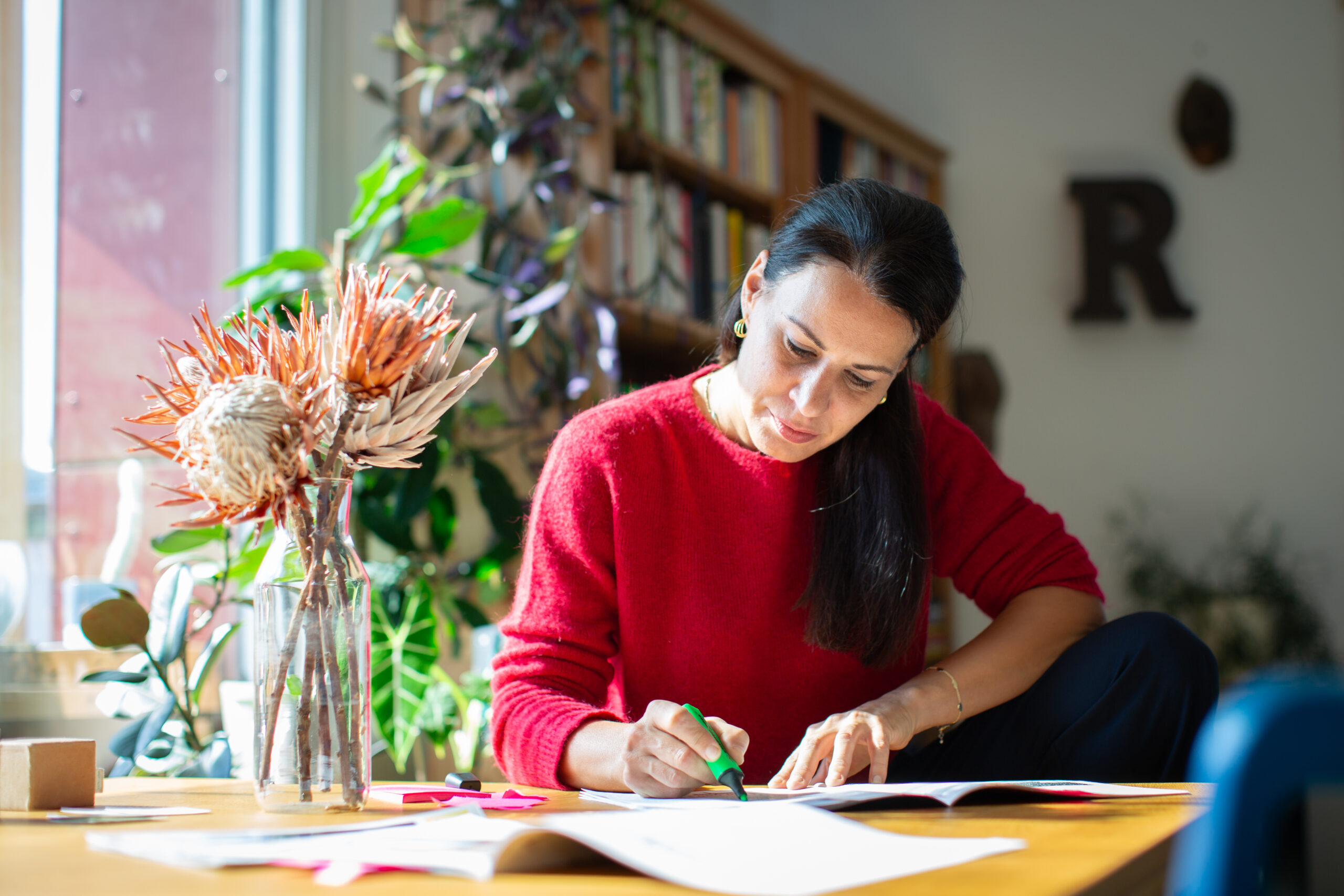 Redakteurin Irene Steindl arbeitet konzentriert an Texten mit farbigen Markern an einem Schreibtisch